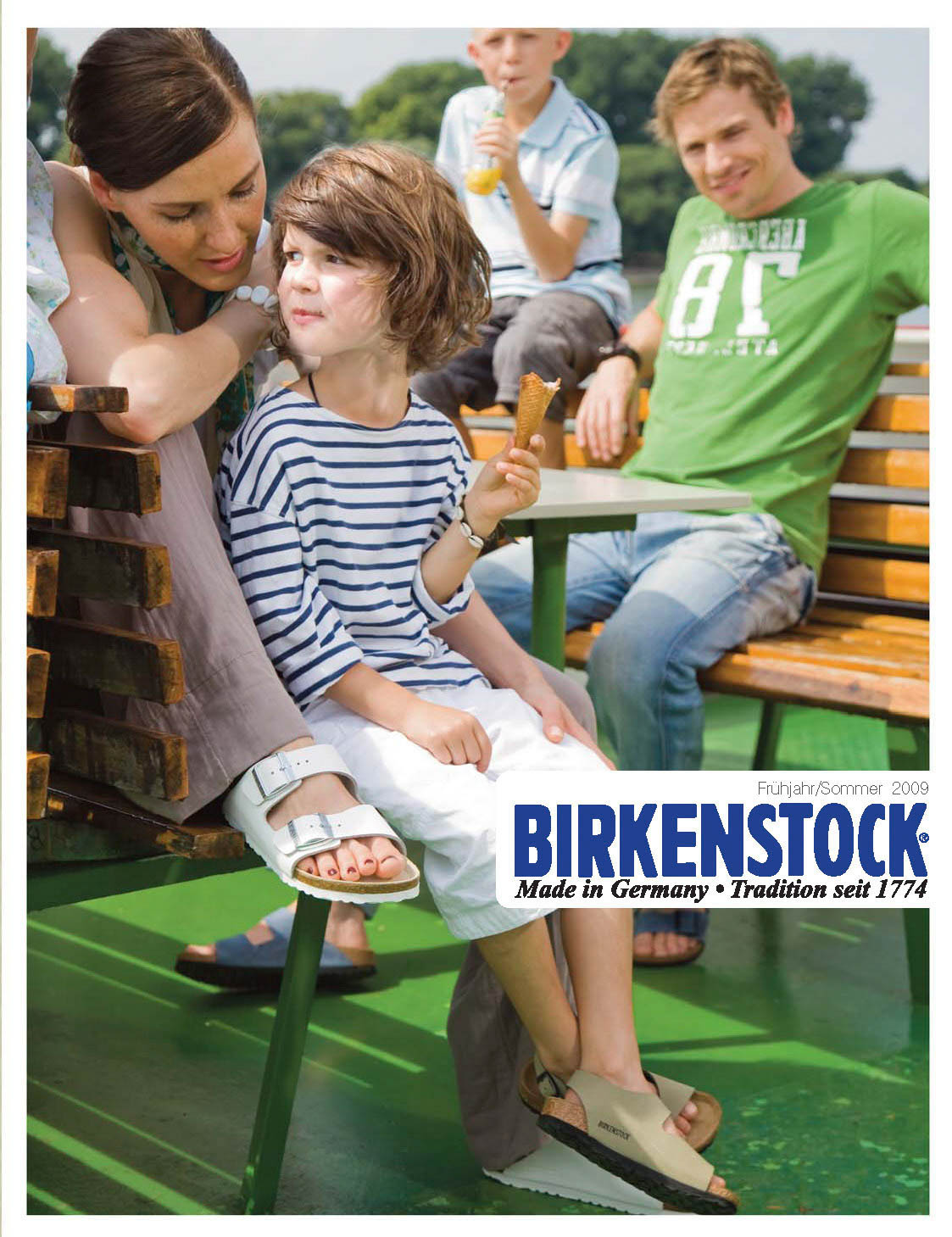 Eine Mutter und ihr kleiner Sohn essen an einem sonnigen Tag auf einer Parkbank ein Eis. Im Hintergrund sind ein weiterer Junge und ein Mann zu sehen. Am unteren Bildrand ist ein Werbebanner von Birkenstock eingeblendet. © Fotografie Tomas Rodriguez