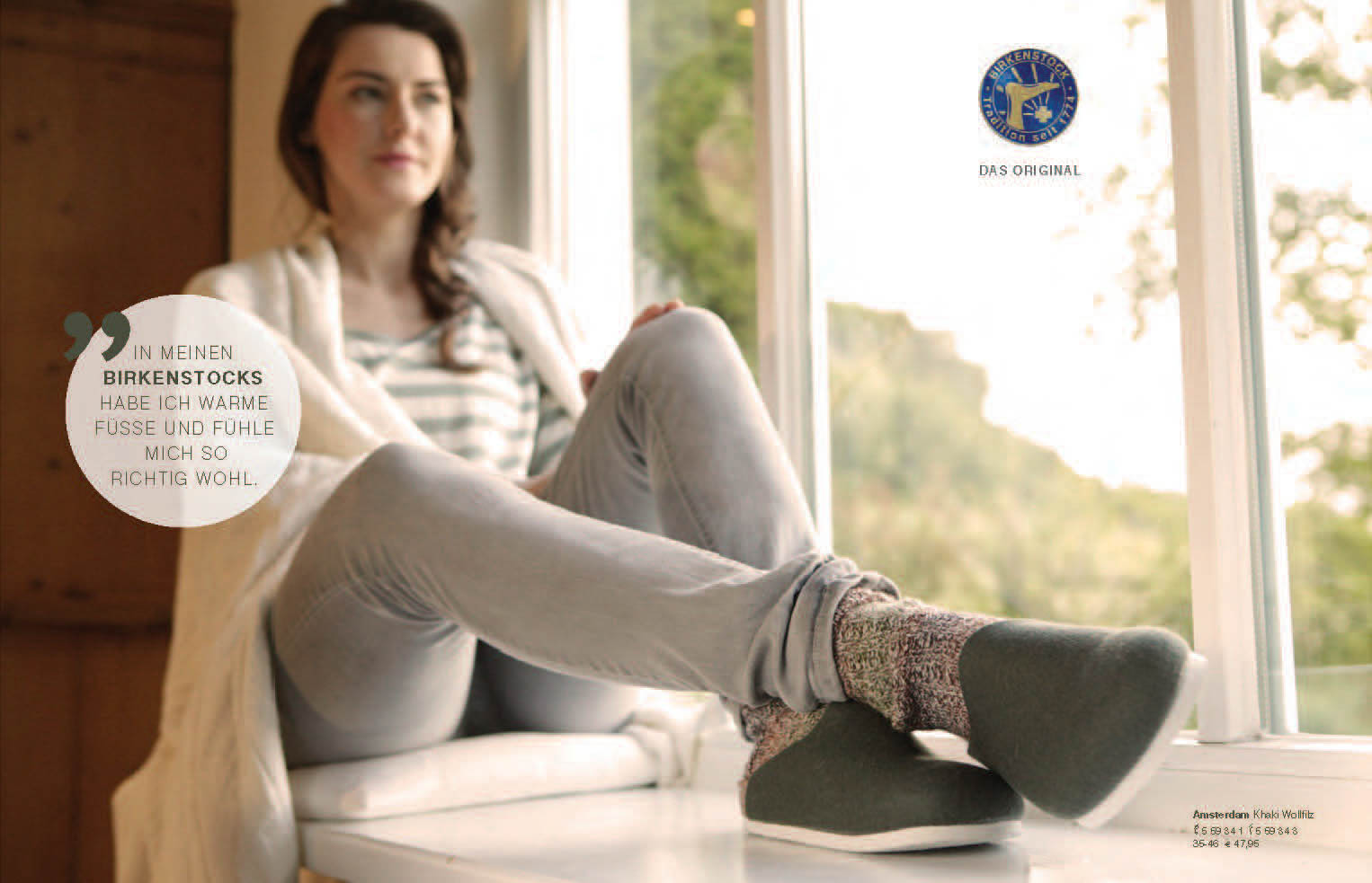 Eine Frau sitzt mit ausgestreckten Beinen an einem Fenster und trägt Birkenstock-Schuhe und Socken. Text und Logo werden überlagert angezeigt. Dies suggeriert eine gemütliche, entspannte Atmosphäre. © Fotografie Tomas Rodriguez