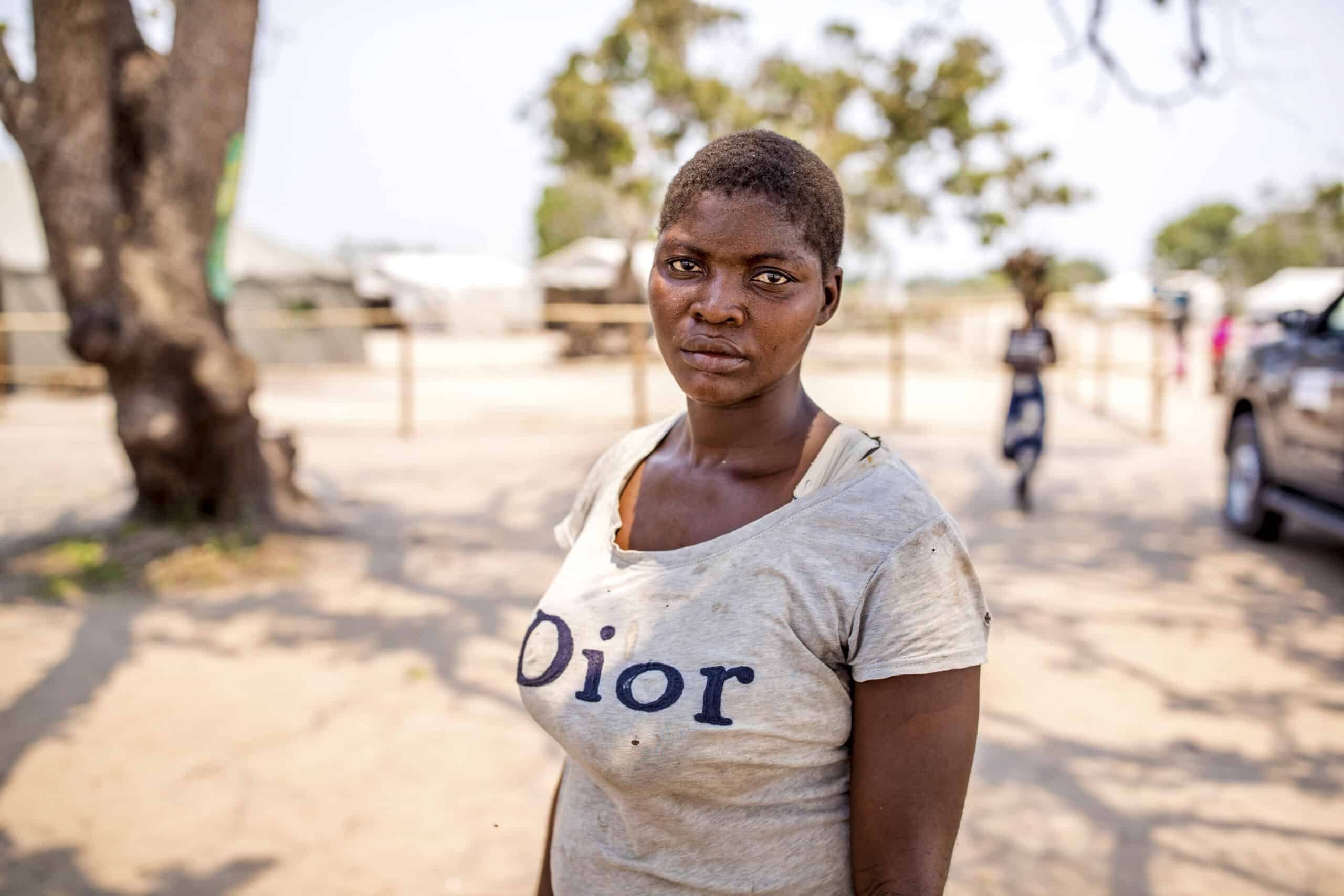 Eine junge Frau steht im Freien in einer ländlichen Umgebung. Sie trägt ein T-Shirt mit der Aufschrift „Dior“ und blickt mit ernster Miene direkt in die Kamera. © Fotografie Tomas Rodriguez