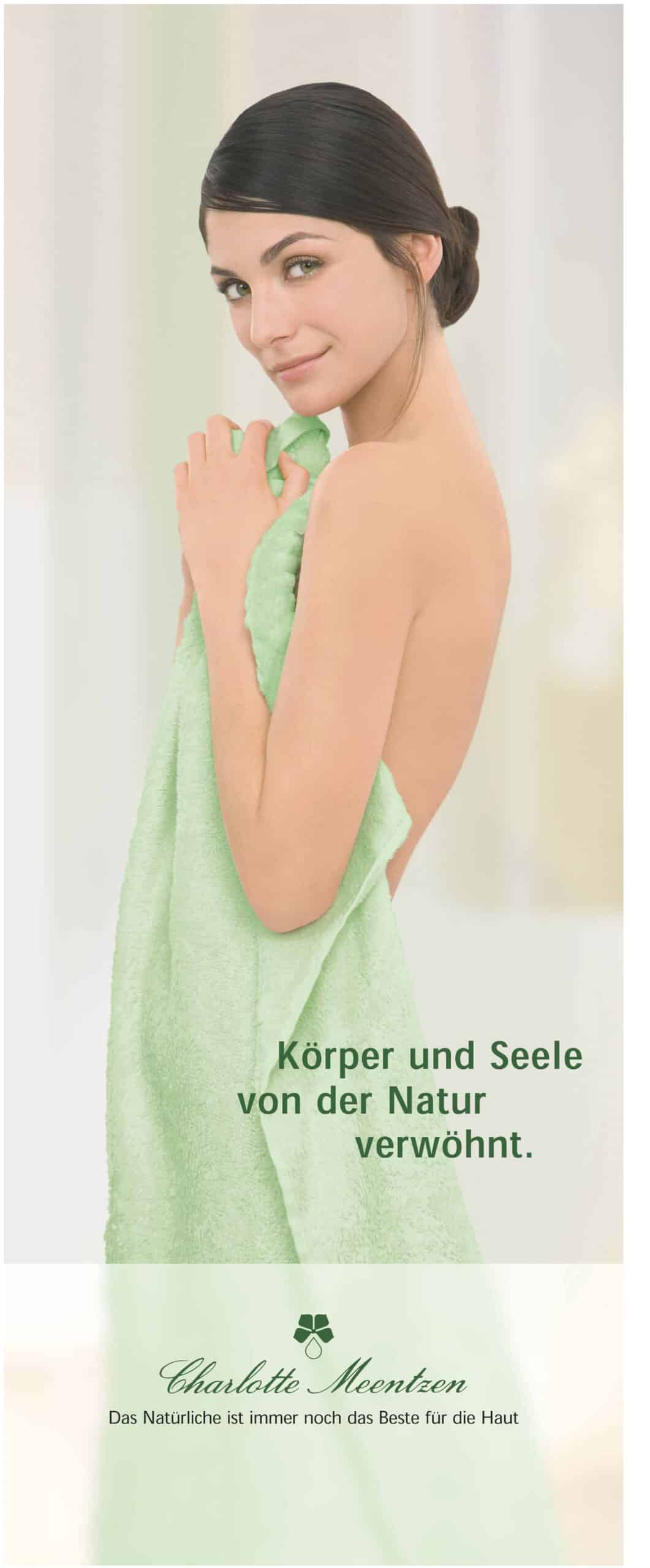 Eine in ein grünes Handtuch gehüllte Frau lächelt vor einem hellen Hintergrund über ihre Schulter, während der deutsche Text eine natürliche Verwöhnung für Körper und Seele andeutet. © Fotografie Tomas Rodriguez