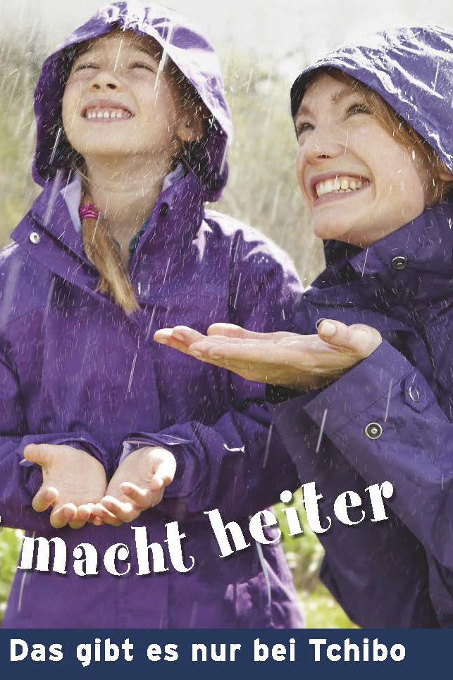 Eine fröhliche Frau und ein junges Mädchen in lila Regenmänteln lächeln und fangen Regentropfen, darunter steht der Text „macht heiter“ und „das gibt es nur bei Tchibo“. © Fotografie Tomas Rodriguez