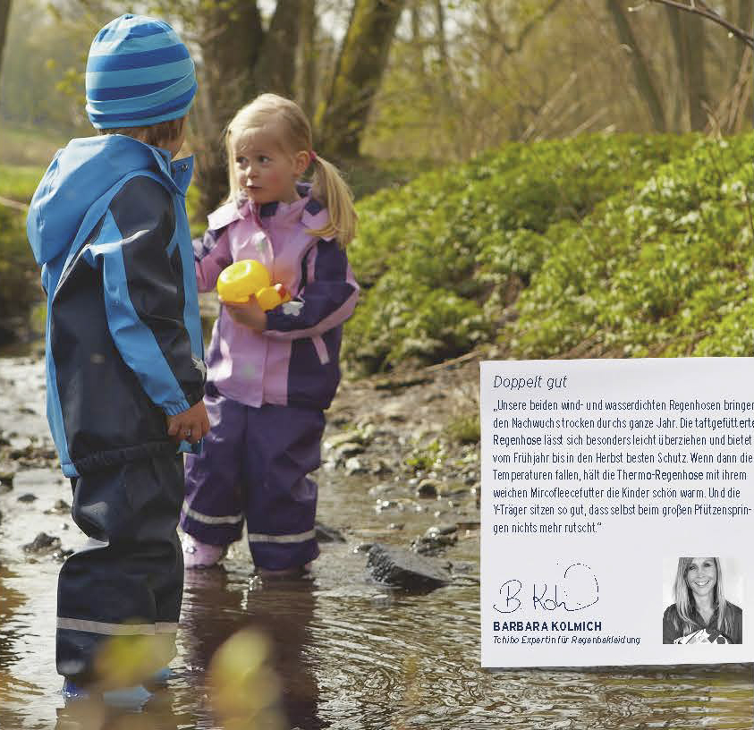 Zwei kleine Kinder, ein Junge in einer blauen Jacke und ein Mädchen in einer rosa Jacke, stehen neben einer Pfütze in einem Park und spielen mit einer gelben Gummiente. © Fotografie Tomas Rodriguez