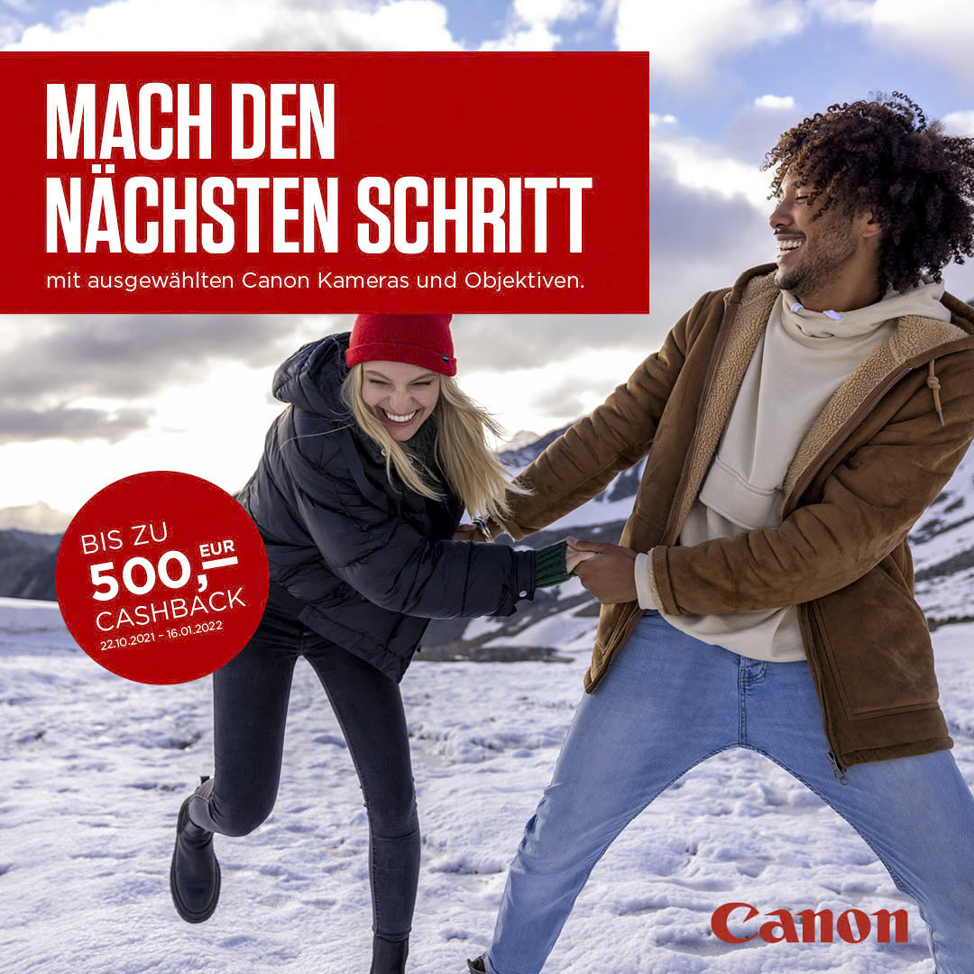 Ein Mann und eine Frau halten sich verspielt an den Händen und lächeln in einer verschneiten Berglandschaft. Beide tragen warme Kleidung. Der deutsche Text im Bild bewirbt Canon-Kameras und -Objektive mit Cashback-Angeboten bis zu 500 Euro. Unten ist das Canon-Logo abgebildet. © Fotografie Tomas Rodriguez