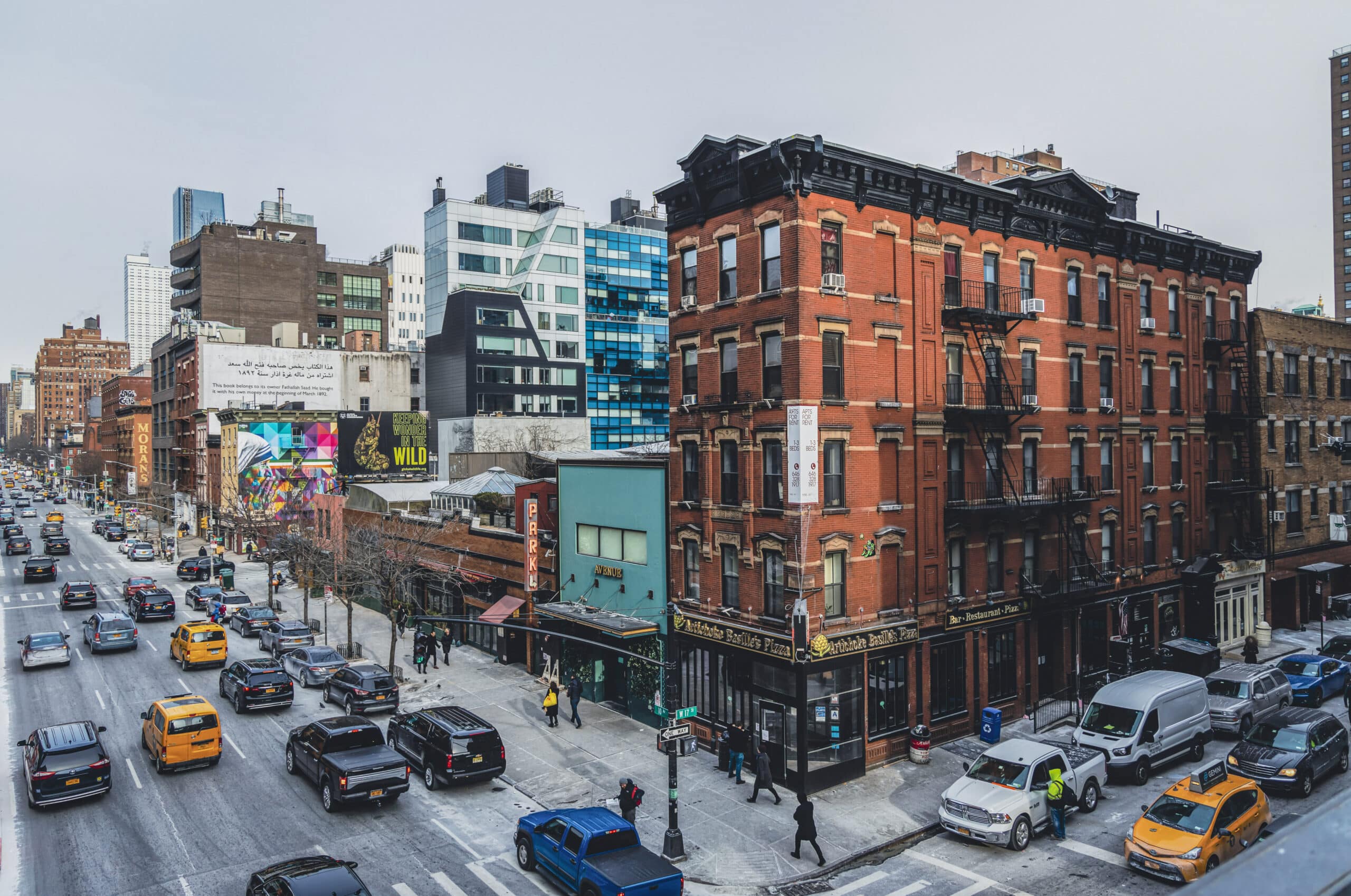 Ein belebtes urbanes Straßenbild mit traditionellen roten Backsteingebäuden, flankiert von moderner Architektur, Verkehr und Fußgängern, das die dynamische Mischung aus Alt und Neu in einer Stadt hervorhebt. © Fotografie Tomas Rodriguez