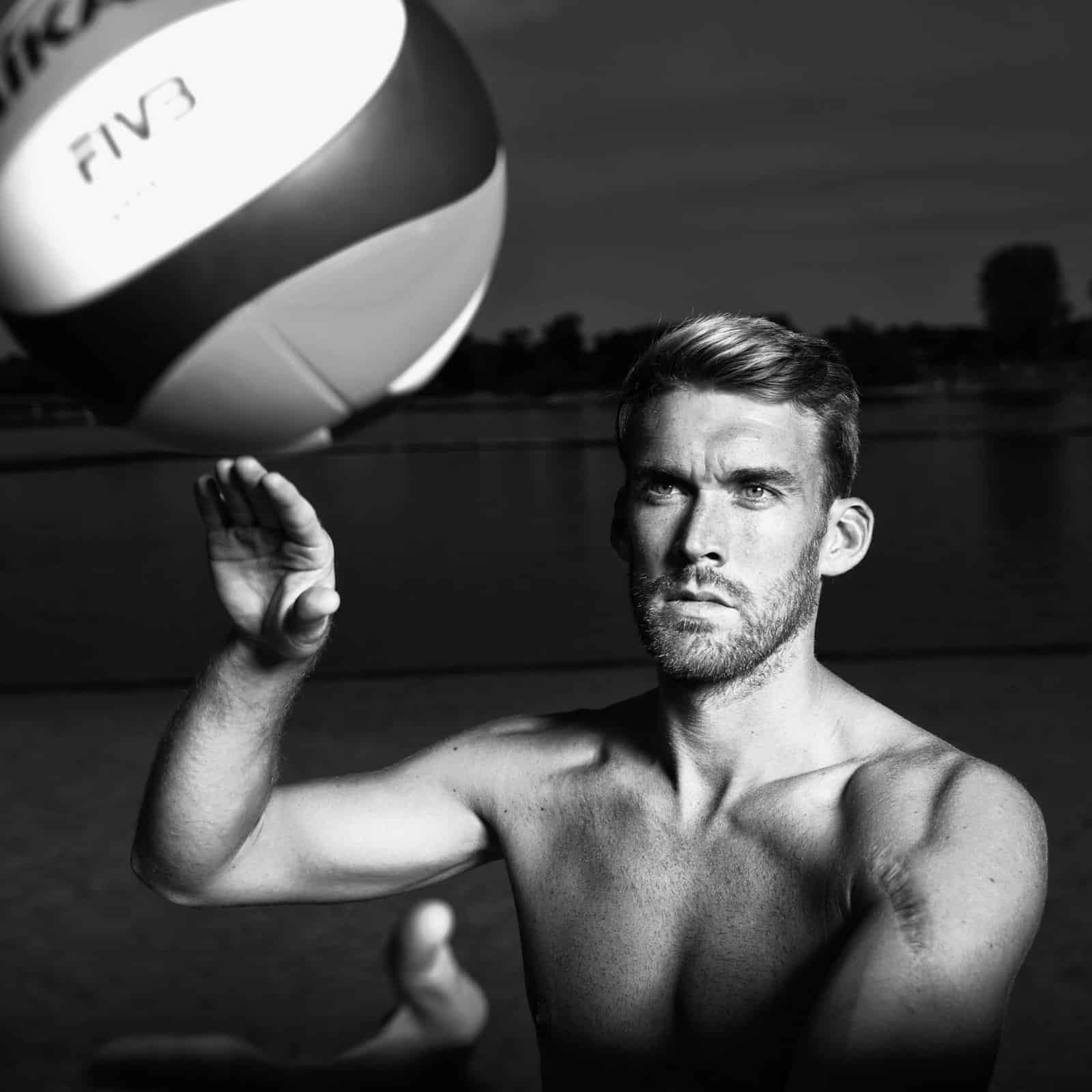 Volleyball Spieler beim Aufschlag, Ein See im ist Hintergrund zu sehen