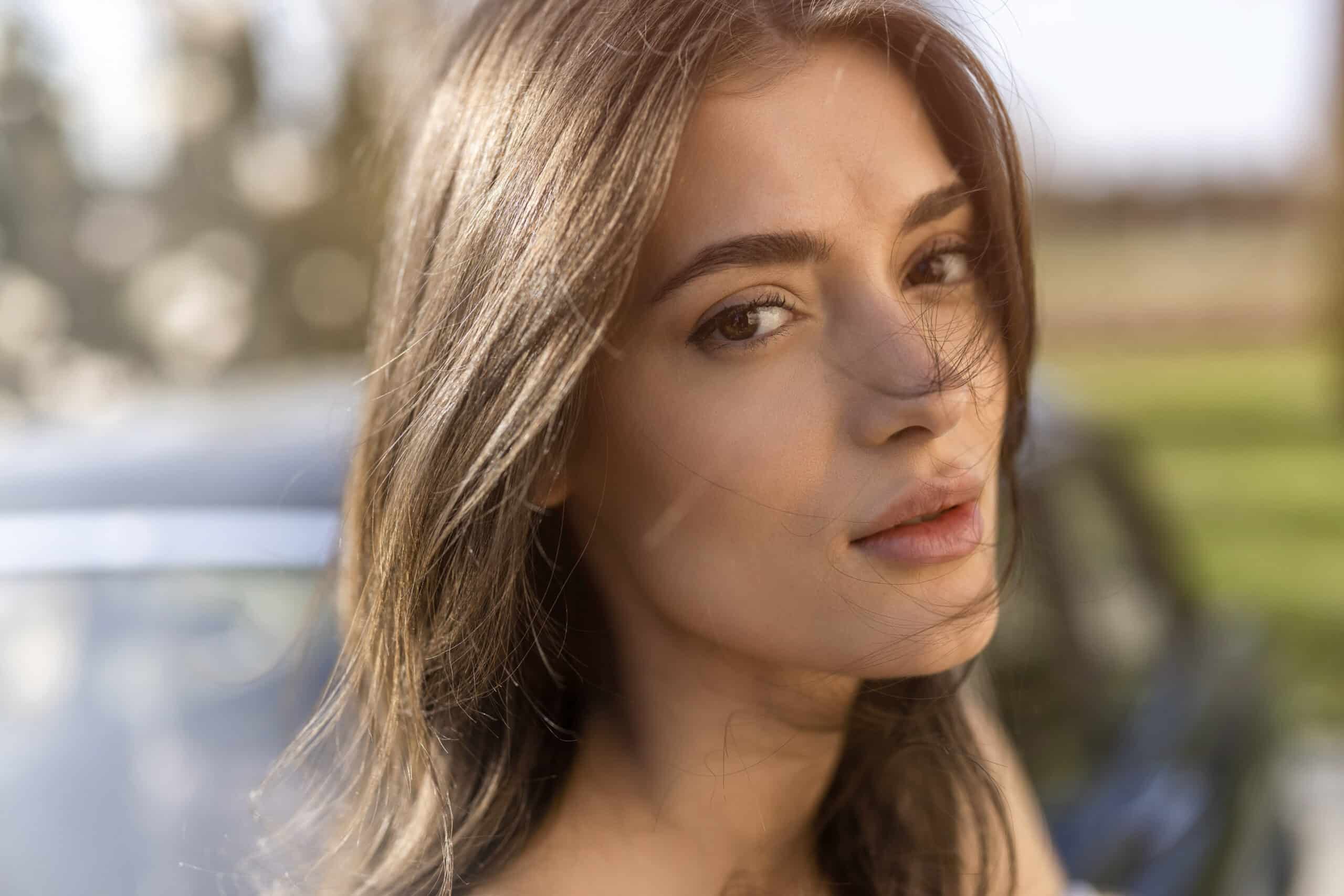 Portrait einer Frau vor einem Oldtimer im grünen