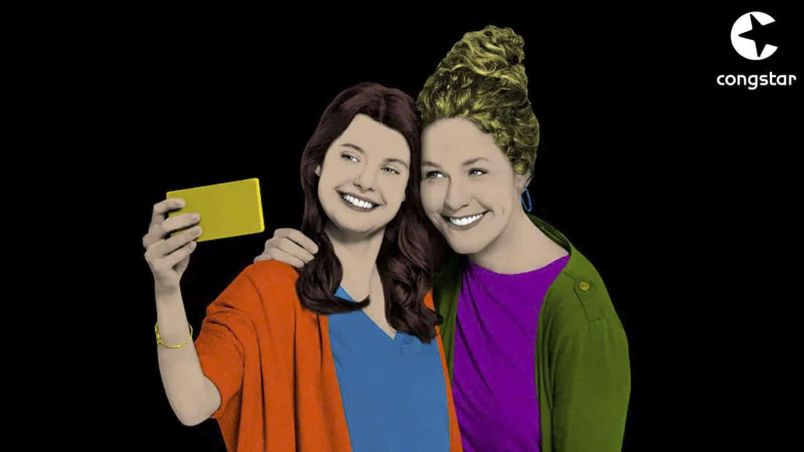 Zwei animierte Frauen posieren für ein Selfie vor schwarzem Hintergrund. Eine hält ein Smartphone in der Hand, beide lächeln. Die Frau links trägt eine orangefarbene Strickjacke, die andere einen grünen Mantel und geflochtene Haare. Oben rechts ist das Logo von Congstar zu sehen. © Fotografie Tomas Rodriguez
