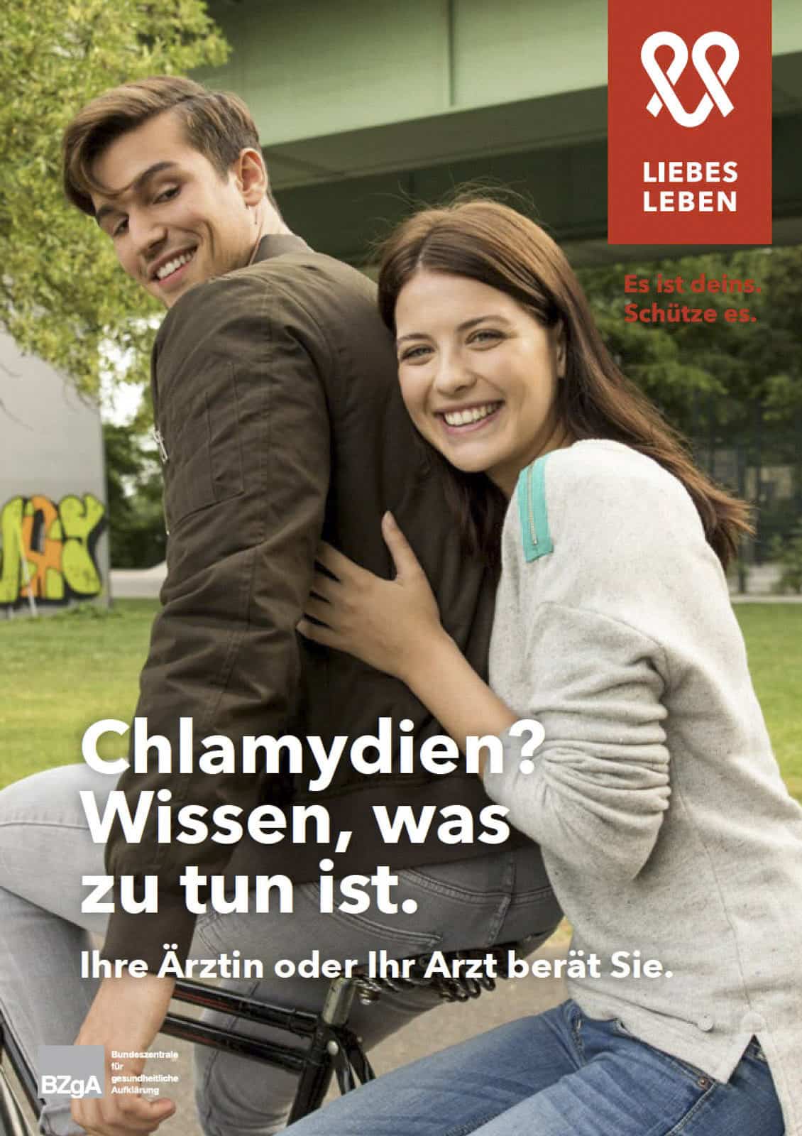 Ein lächelndes Paar, eine Frau sitzt auf einem Fahrrad und ein Mann steht neben ihr. Sie stehen draußen in der Nähe einer grünen Brücke. Der Text auf dem Bild ist auf Deutsch und spricht über Chlamydien-Aufklärung und empfiehlt, einen Arzt aufzusuchen. © Fotografie Tomas Rodriguez