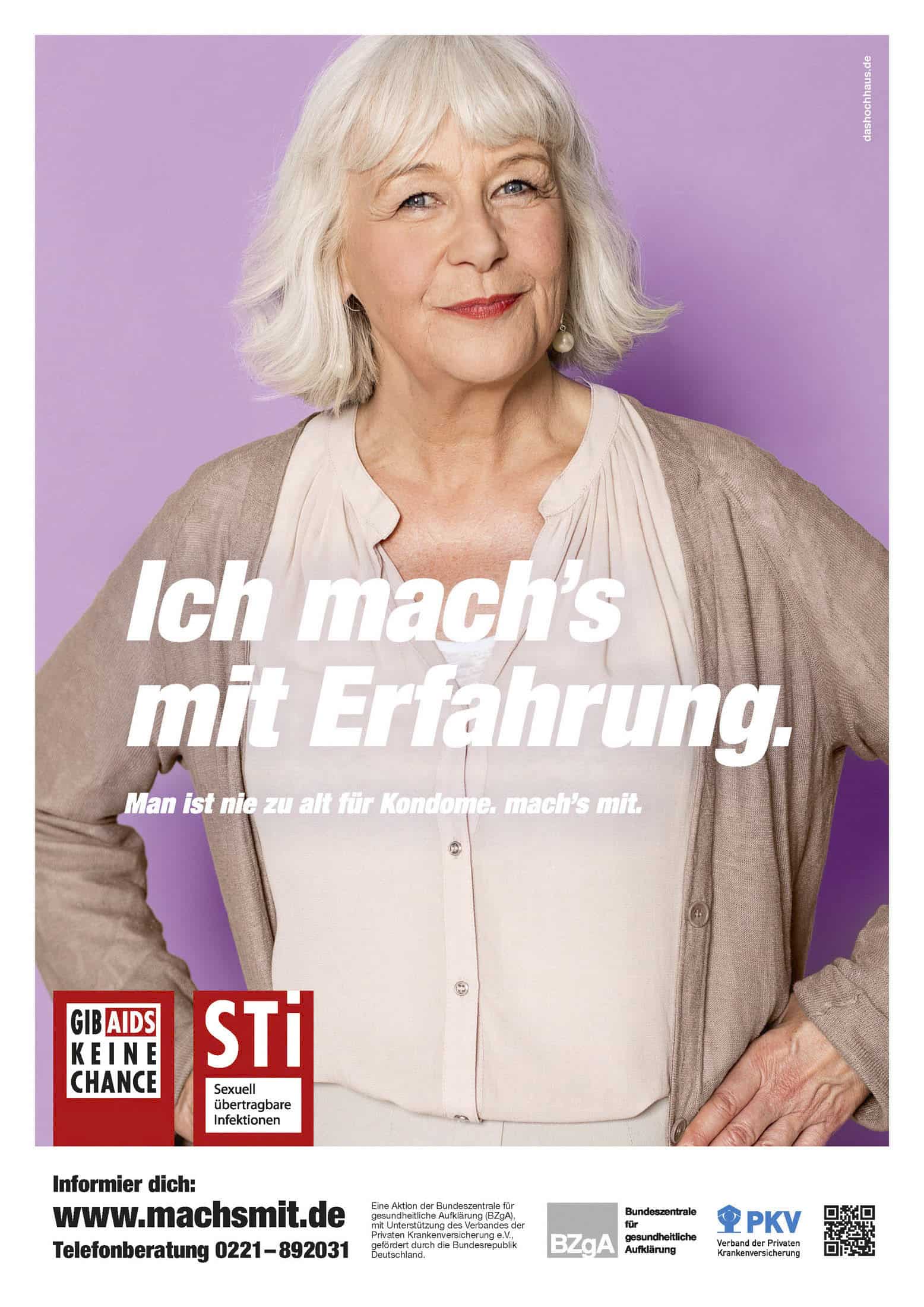 Eine ältere Person mit weißem Haar und einem sanften Lächeln steht selbstbewusst vor einem violetten Hintergrund. Sie trägt ein neutrales Outfit mit einer leichten Strickjacke. Das Poster fördert das Bewusstsein für sexuell übertragbare Krankheiten und enthält einen Text, der zur Verwendung von Kondomen in jedem Alter auffordert. © Fotografie Tomas Rodriguez