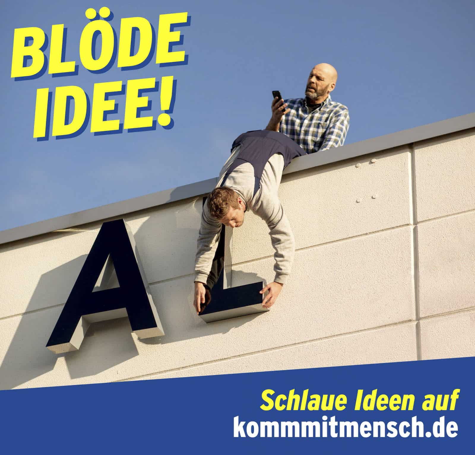 Eine Person lehnt gefährlich über der Kante eines Gebäudes und hält sich an einem großen „L“ fest, während eine andere Person dahinter steht und auf ihr Telefon schaut. Der Text lautet „Blöde Idee! Schlaue Ideen auf kommmitmensch.de.“. © Fotografie Tomas Rodriguez