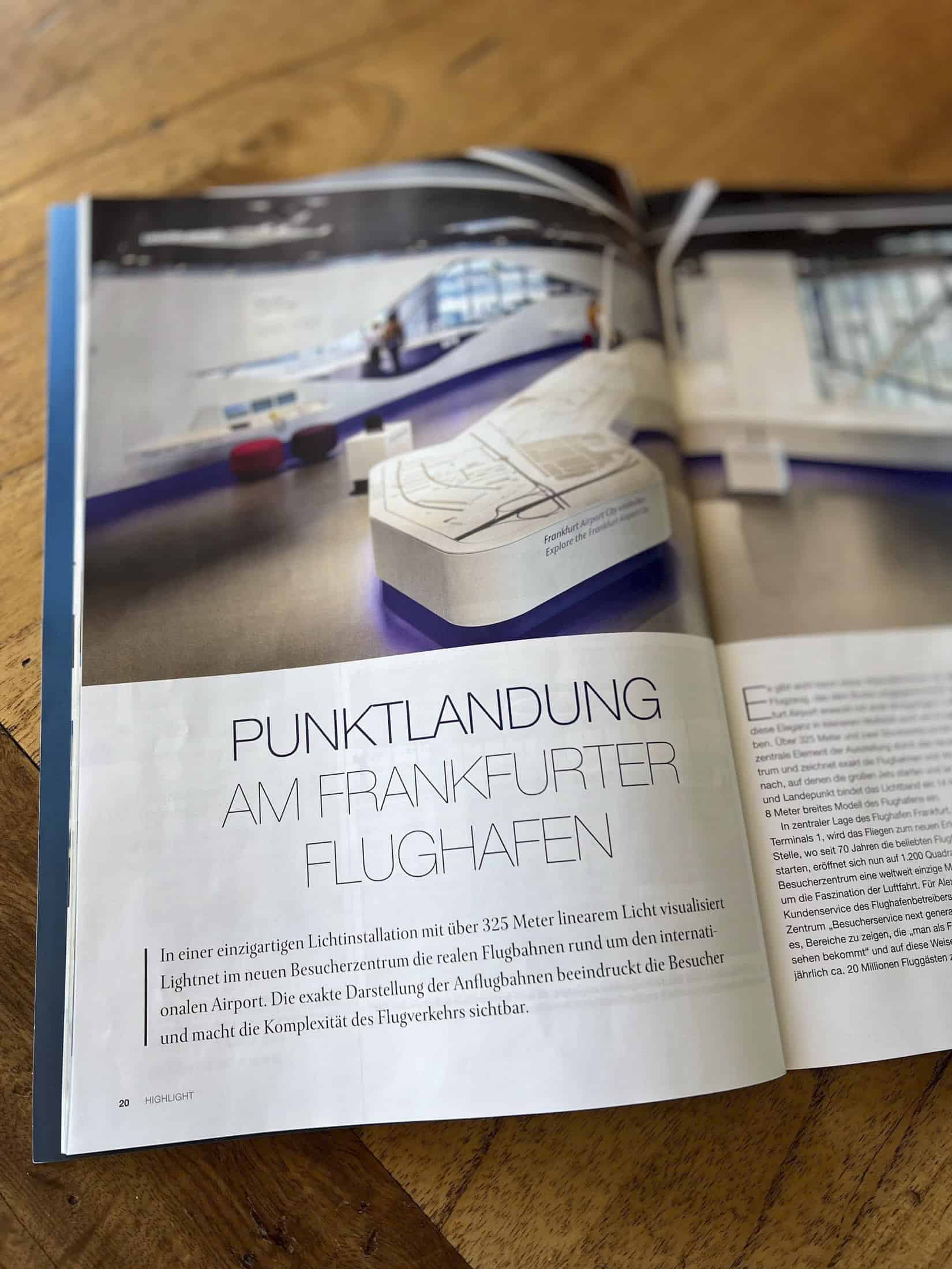 Open Magazine zeigt einen Artikel mit der Überschrift „Punktlandung am Frankfurter Flughafen“ auf Deutsch. Das Bild zeigt eine Seite mit Text und im Hintergrund eine Lichtkunstinstallation, die an einen Flughafenplan erinnert. © Fotografie Tomas Rodriguez