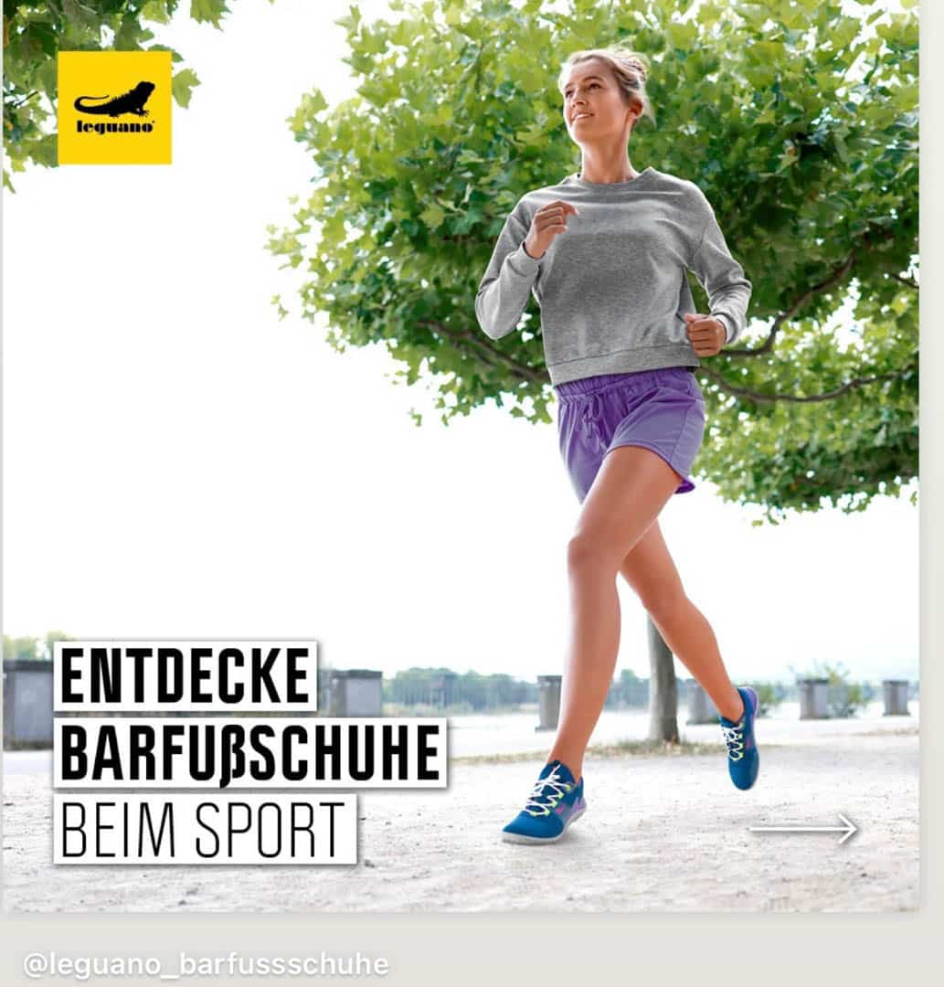 Eine Person joggt im Freien. Sie trägt ein graues Sweatshirt, lila Shorts und leuchtend blaue Schuhe. Sie ist auf einem Pfad mit Bäumen im Hintergrund. Der Text auf dem Bild lautet „Entdecke Barfußschuhe beim Sport“. © Fotografie Tomas Rodriguez