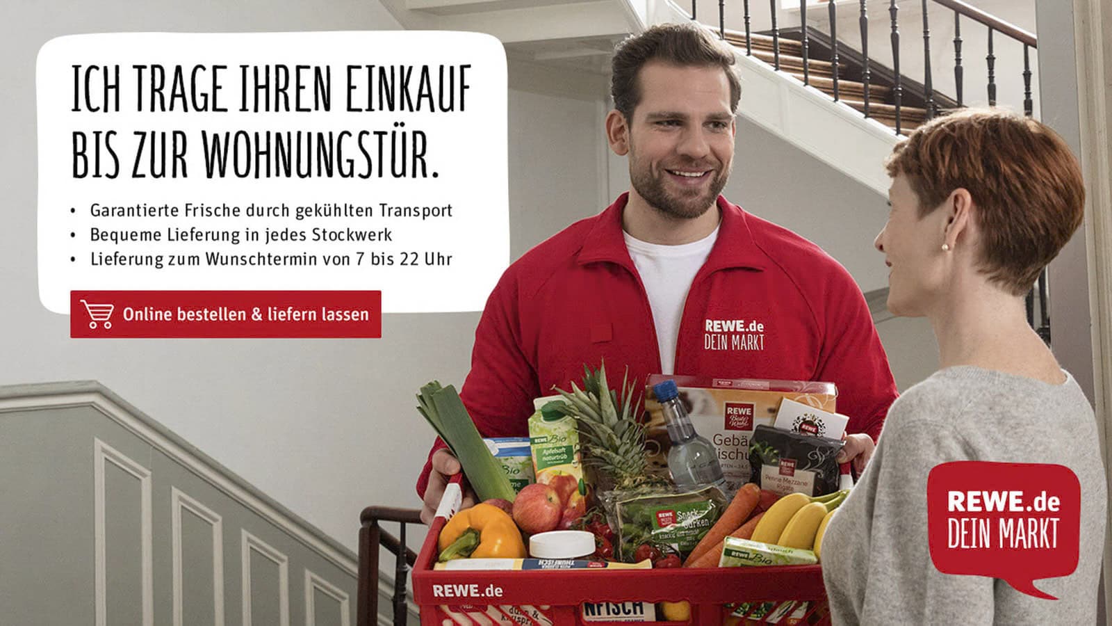 Ein lächelnder REWE-Lieferant überreicht einer Frau an ihrer Wohnungstür einen mit Lebensmitteln gefüllten roten Korb. Der deutsche Text hebt die Vorteile der Hauszustellung hervor, wie z. B. den frischen Transport und die bequemen Lieferzeiten. © Fotografie Tomas Rodriguez