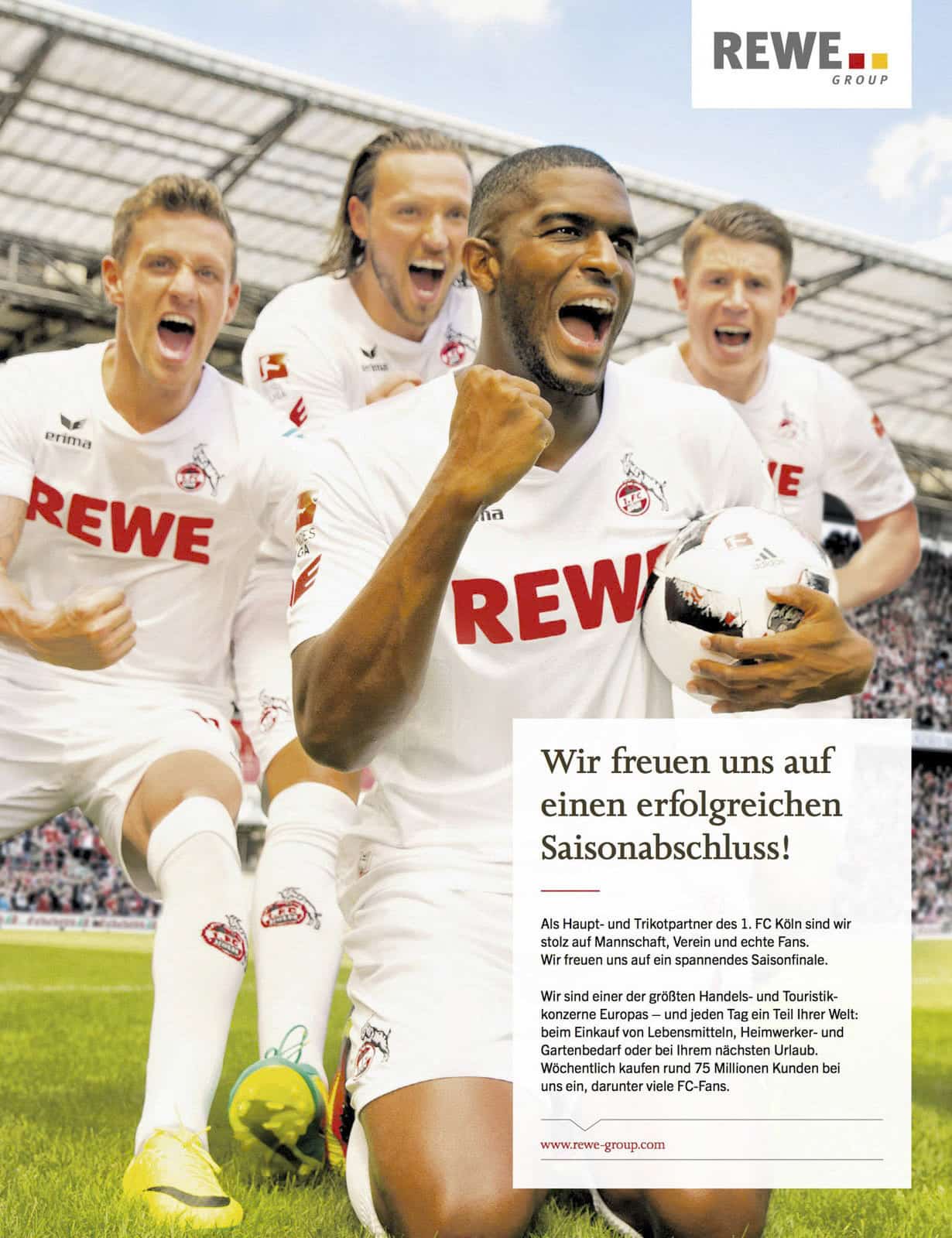 Vier begeisterte Fußballspieler in weißen FC Köln Trikots feiern auf einem Feld, einer hält einen Ball und jubelt, mit einem Stadion und jubelnden Fans im Hintergrund. In der unteren rechten Ecke erscheint eine Werbung der REWE GROUP. © Fotografie Tomas Rodriguez