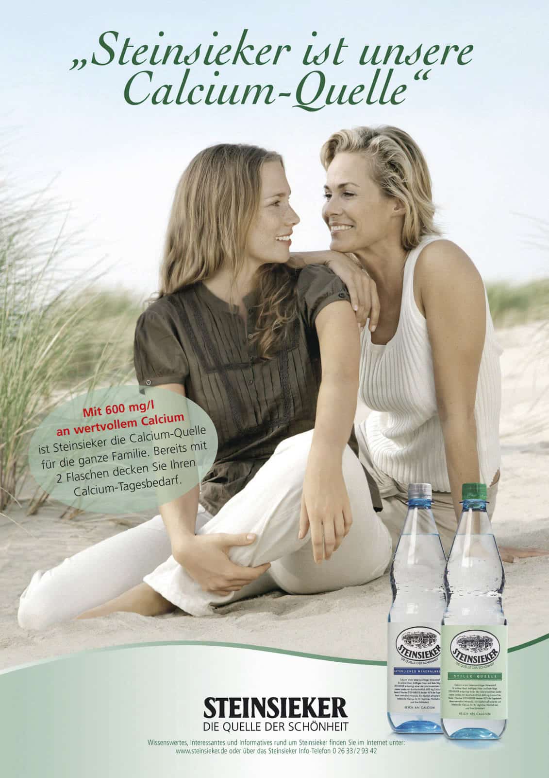 Eine lächelnde Frau und ein Mädchen im Teenageralter sitzen zusammen an einem Sandstrand mit Gras und umarmen sich. Im Vordergrund stehen zwei Flaschen mit Steinsieker Mineralwasser. Der Text wirbt für den Kalziumgehalt des Wassers. © Fotografie Tomas Rodriguez