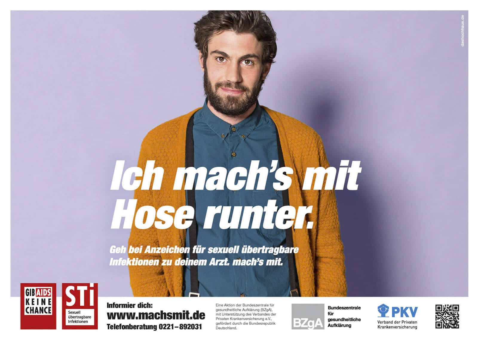 Ein bärtiger Mann mit gewelltem Haar, der eine senfgelbe Strickjacke über einem blaugrünen Hemd trägt, steht vor einem lila Hintergrund. Der deutsche Text wirbt für das Bewusstsein für sexuell übertragbare Infektionen und ermutigt zu einem Arztbesuch bei entsprechenden Symptomen. © Fotografie Tomas Rodriguez