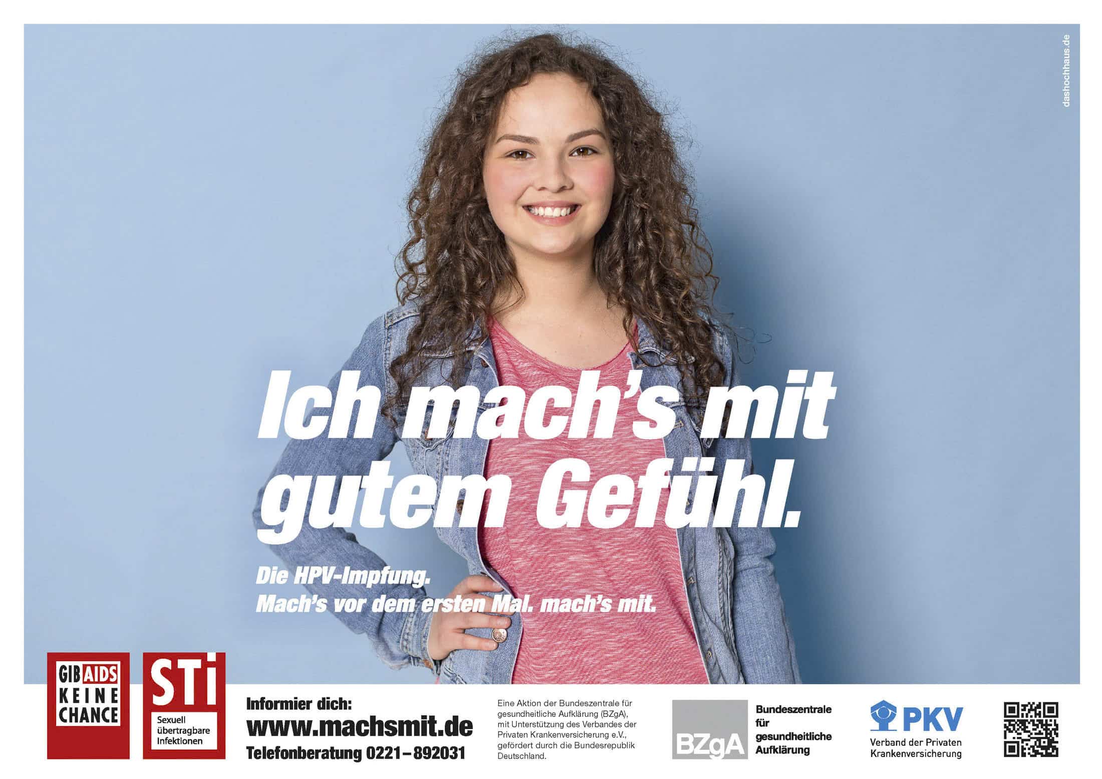 Eine junge Frau mit lockigem Haar lächelt selbstbewusst in die Kamera. Sie steht vor einem hellblauen Hintergrund und hat die Hand in die Hüfte gestemmt. Der Text in deutscher Sprache wirbt für die HPV-Impfung und sichere sexuelle Gesundheitspraktiken. © Fotografie Tomas Rodriguez
