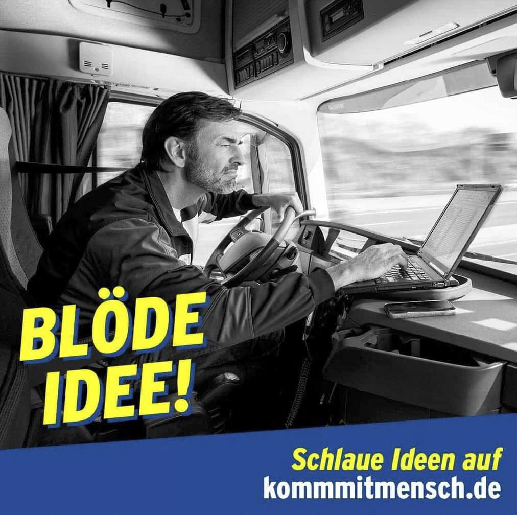 Ein Mann sitzt in einer LKW-Kabine und tippt während der Fahrt auf einem Laptop, der auf dem Lenkrad steht. In gelber Schrift steht "BLÖDE IDEE!" und in blauer Schrift darunter wird für "Schlaue Ideen auf kommmitmensch.de" geworben. © Fotografie Tomas Rodriguez