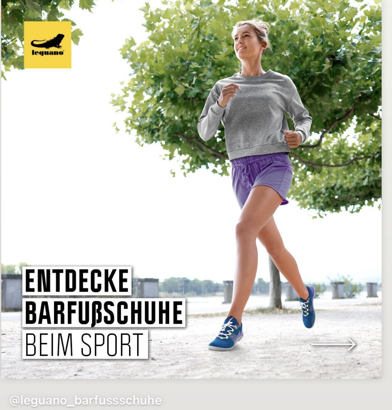 Eine Frau in einem grauen Sweatshirt und lila Shorts joggt an einem hellen, sonnigen Tag im Freien und trägt blaue Barfußschuhe. Der Text auf dem Bild lautet: "ENTDECKE BARFUSSSCHUHE BEIM SPORT. © Fotografie Tomas Rodriguez